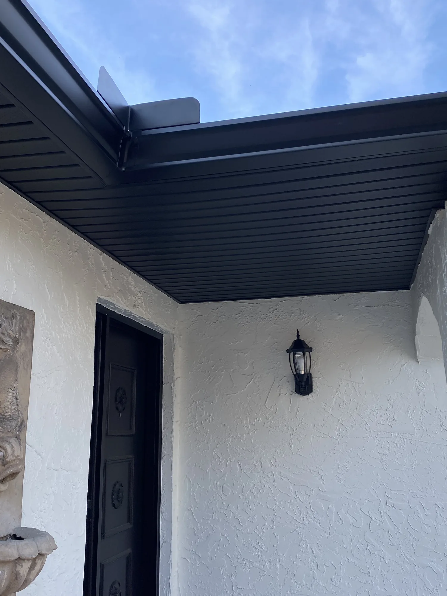 Dark gutter, soffit and fascia at a residential entry