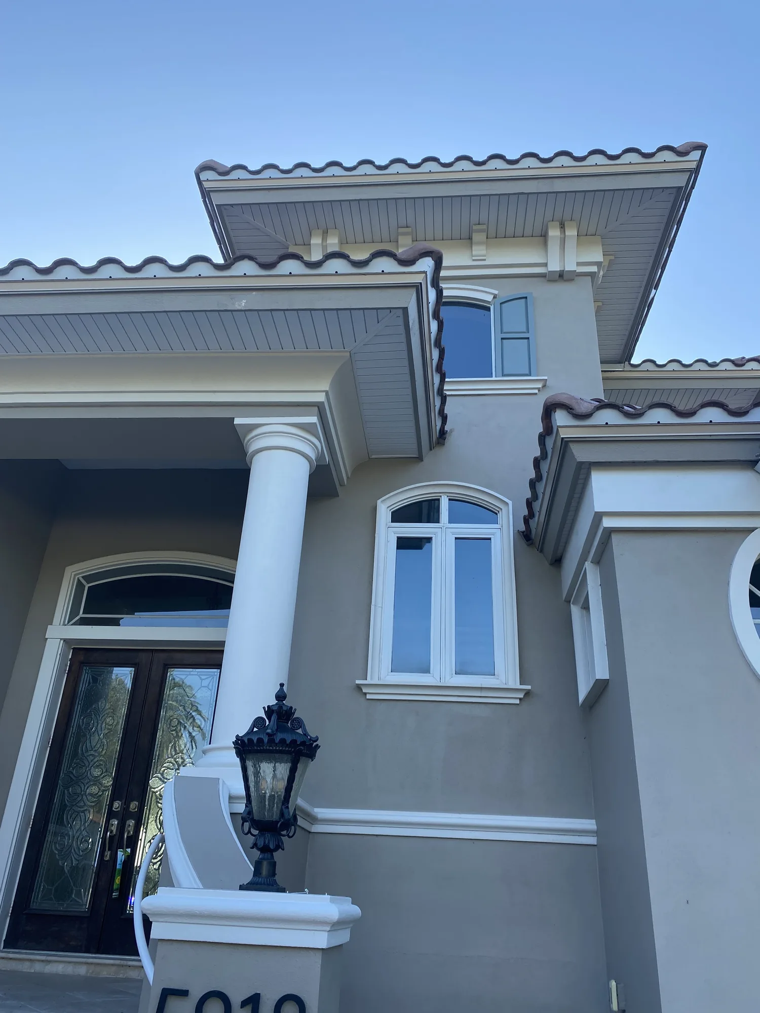 White soffit installation beneath a multistory residential roofline